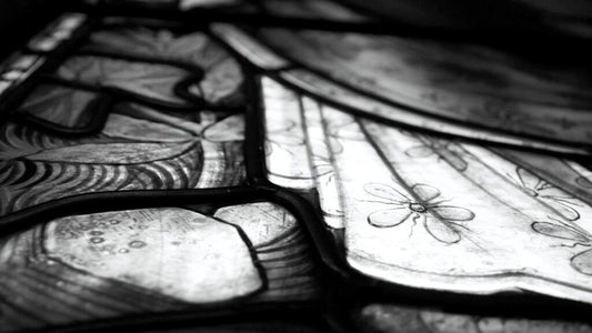 Close up of a stained glass panel in greyscale